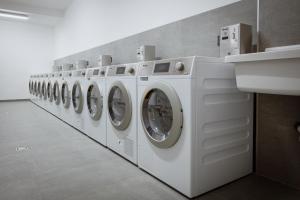 a row of white washing machines in a laundry room at Schafalm Dahoam in Schladming