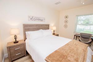 Schlafzimmer mit einem großen weißen Bett und einem Schreibtisch in der Unterkunft Heather Lakes Retreat in Brandon