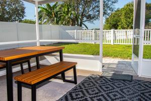 a wooden table and a bench on a patio at Heather Lakes Retreat in Brandon