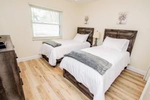two beds in a room with wooden floors at Heather Lakes Retreat in Brandon +42 photos