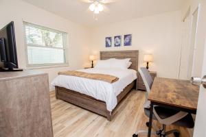 um quarto com uma cama, uma secretária e uma televisão em Heather Lakes Retreat em Brandon