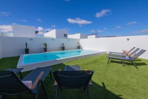 a patio with chairs and a swimming pool on a building at Villa Casilla de Costa Private Pool Luxury La Oliva By Holidays Home in La Oliva