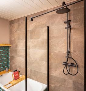 a shower stall in a bathroom with a bath tub at ZOLLHOES Zoek de grens op! in Barenfleer