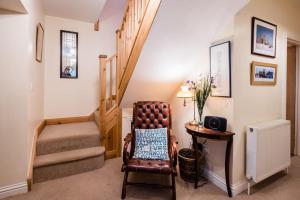 een woonkamer met een stoel en een trap bij Beachcombers in Kent