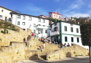 a group of people sitting on stairs in a town at Getxo Garden Houses - The Suite in Getxo