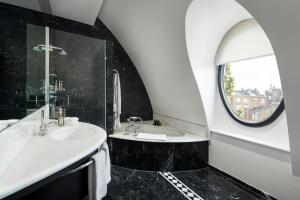 a black and white bathroom with a sink and a mirror at COMO The Halkin in London