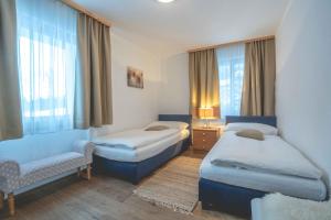 1 dormitorio con 2 camas, silla y ventana en Chalet Talisman, en Zermatt