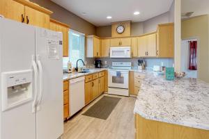 a kitchen with white appliances and wooden cabinets at Sittin' By The Sea in Pacific City