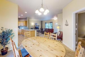 a dining room and kitchen with a wooden table and chairs at Sittin' By The Sea in Pacific City +19 photos