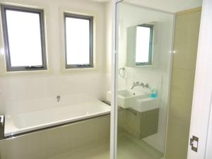 a bathroom with a tub and a sink and a shower at 170 Hazards View - Unit 1 in Coles Bay