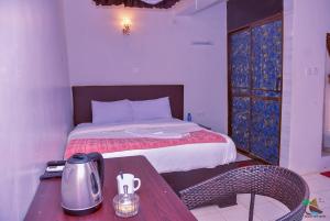 a bedroom with a bed and a table with a tea kettle at Beach View Hotel - Kisumu in Kisumu