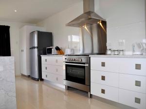 a kitchen with a stove and a refrigerator at 170 Hazards View - Unit 1 in Coles Bay +3 photos