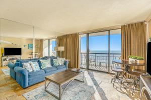 a living room with a blue couch and a view of the ocean at Gulf Overlook San Luis Resort 1035 in Galveston