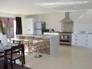 a kitchen with a counter and a table and chairs at 170 Hazards View - Unit 1 in Coles Bay