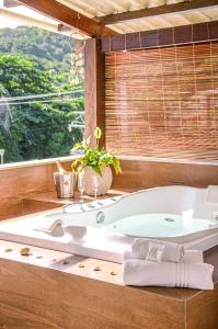 La salle de bains est pourvue d'une baignoire et d'une fenêtre. dans l'établissement Condominio Luna Rossa, à Morro de São Paulo