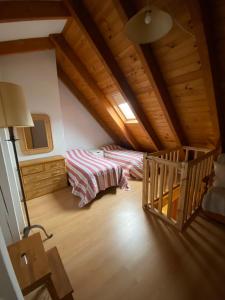 a attic room with two beds and a staircase at Duplex Sky, muy cerca estación ski, Bonito y acogedor in Pla de l'Ermita