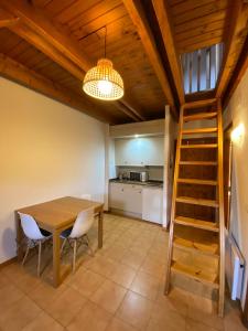 a kitchen and dining room with a wooden table and chairs at Duplex Sky, muy cerca estación ski, Bonito y acogedor in Pla de l'Ermita