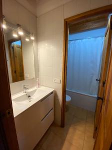 a bathroom with a sink and a toilet and a mirror at Duplex Sky, muy cerca estación ski, Bonito y acogedor in Pla de l'Ermita