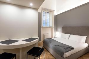 a bedroom with a bed and a table and a window at Palazzo Liberati Apartments in Parma