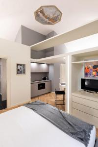 a bedroom with a large bed and a kitchen at Palazzo Liberati Apartments in Parma