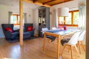 ein Esszimmer und ein Wohnzimmer mit Tisch und Stühlen in der Unterkunft Alpenchalet Sachrang in Sachrang