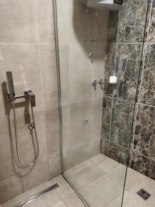 uma casa de banho com um chuveiro e uma porta de vidro em Apartman Herceg em Mostar