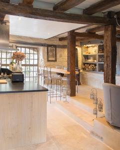 uma cozinha com vigas de madeira e um balcão com bancos em Maison Lapopie chambres et gîte em Saint-Cirq-Lapopie