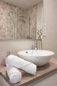 a bathroom with a white sink and towels on a counter at Apartamento Premium PLAZA MAYOR con PARKING in Avila