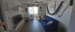 sala de estar con sofá azul y TV en Apartamento Geminis, en La Manga del Mar Menor