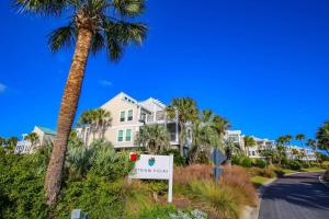 a palm tree and a sign in front of condos at Seaside Therapy~ in Seabrook Island