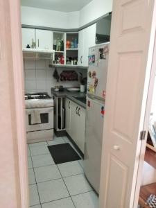 a white kitchen with a refrigerator and a stove at Hermoso departamento frente al Mar in Viña del Mar