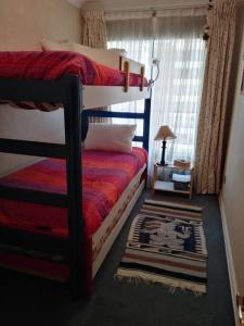 a bedroom with two bunk beds and a rug at Hermoso departamento frente al Mar in Viña del Mar