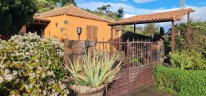 a fence in front of a house with a cactus at La Bodega in Fuencaliente de la Palma
