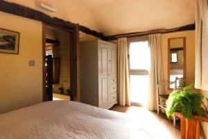 a bedroom with a large bed and a window at Mill Cottage set beside a Mill pond in a 70 acre Nature Reserve Bliss in Assington