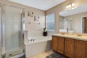 a bathroom with a tub and a sink and a shower at Castle Street Memories in Kissimmee +26 photos