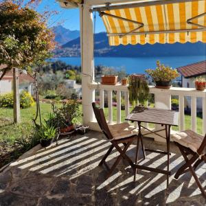 a patio with a table and chairs and an umbrella at Casa Melina 2 in Tremezzo