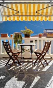 two chairs and a table and an umbrella on a patio at Casa Melina 2 in Tremezzo