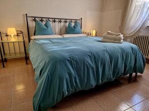 a large bed with a blue blanket on it at Casa Melina 2 in Tremezzo