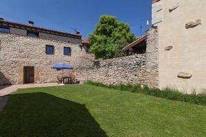 un edificio de piedra con una mesa y una sombrilla en un patio en Casa Palacio de Mave en Mave