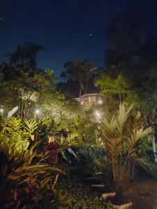 un jardin la nuit avec une maison en arrière-plan dans l'établissement Monte Carmelo Inn Sana, à Macaé