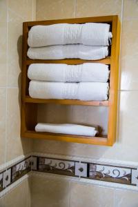 a stack of towels on a shelf in a bathroom at Hotel Camino Nacional Salento in Salento