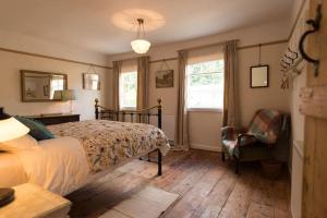 1 dormitorio con 1 cama, 1 silla y 1 ventana en Romney, a cosy Victorian cottage in a picturesque Suffolk village, en Cavendish