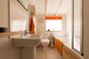 une salle de bain avec un lavabo, des toilettes et une baignoire dans l'établissement Romney, a cosy Victorian cottage in a picturesque Suffolk village, à Cavendish 36 autres photos