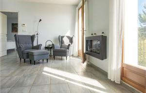 a living room with a tv and chairs and a fireplace at 3 Bedroom Cozy Home In Caunes Minervois in Caunes-Minervois