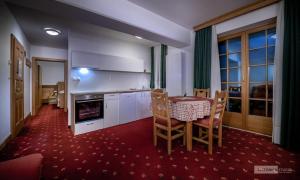 a kitchen with a table and a table and chairs at Garni Hotel Pod Roglo Boharina 2 in Zreče