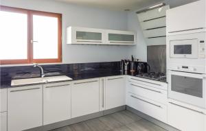 a white kitchen with white cabinets and a sink at 3 Bedroom Cozy Home In Caunes Minervois in Caunes-Minervois