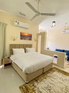 a bedroom with a large white bed with a ceiling at AL shoroq Green Resort in Ghubrat Ţanūf