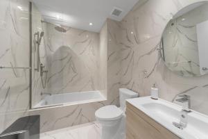 een badkamer met een wastafel, een toilet en een spiegel bij Suites De la Montagne in Montreal
