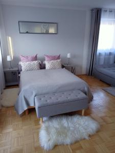 een slaapkamer met een bed met een grijze deken en een kleed bij Maja in Füssen