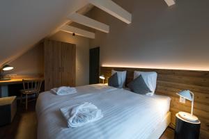 um quarto com uma cama grande com lençóis brancos e almofadas em Alm-Chalet Exclusive 2 em Clausthal-Zellerfeld